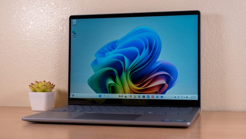 An open silver laptop sits on a brown desk