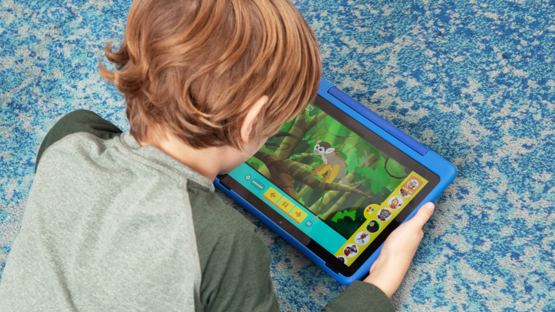 Looking over the shoulder of a kid on the floor watching the tablet.