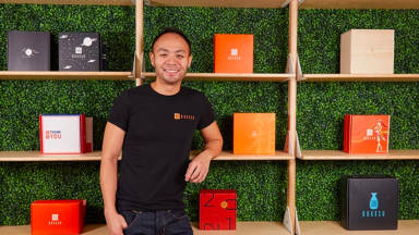 Danny Taing poses in front of Bokksu boxes