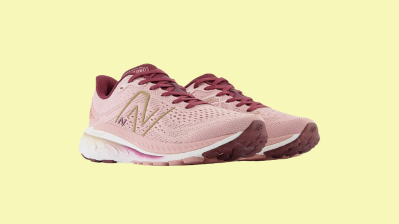A pair of pink sneakers against a yellow background.