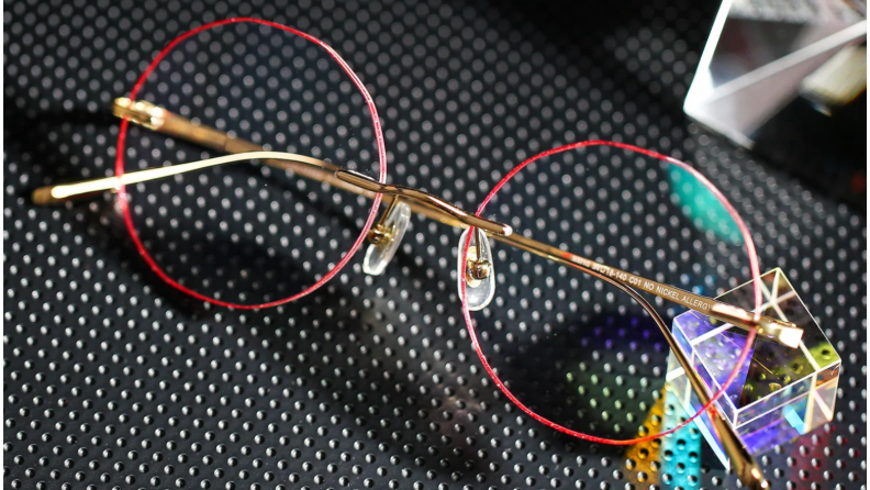 An image of a pair of red-rimmed wire frame glasses.