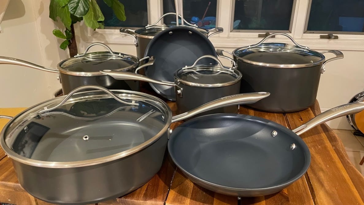 The Guy Fieri’s Flavortown Laser Titanium 12-piece Cookware Set on top of a wooden surface in kitchen.