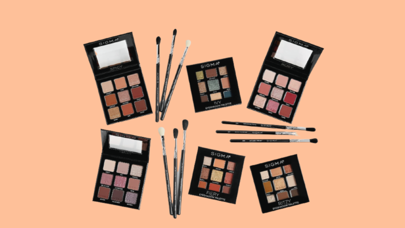 Makeup palettes and brushes against peach background