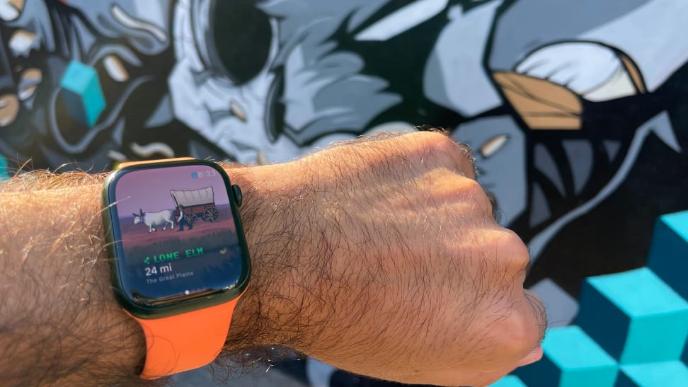 A person holds out their wrist to monitor how far they've walked on the Apple Watch's Oregon Trail app.