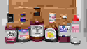 Six different bottles of BBQ sauce side-by-side.