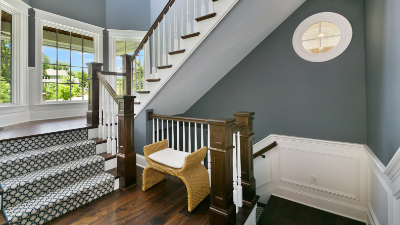 A bench sits on a landing between two staircases