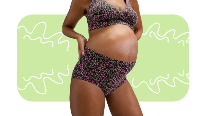 Pregnant model poses with hand on hips while wearing floral printed bra and high rise panty set.