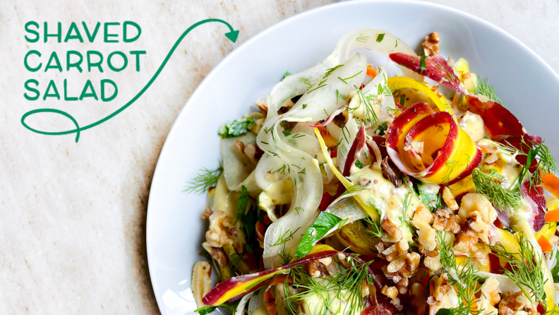 A bowl o f salad with the text "Shaved Carrot Salad" and an arrow pointing.