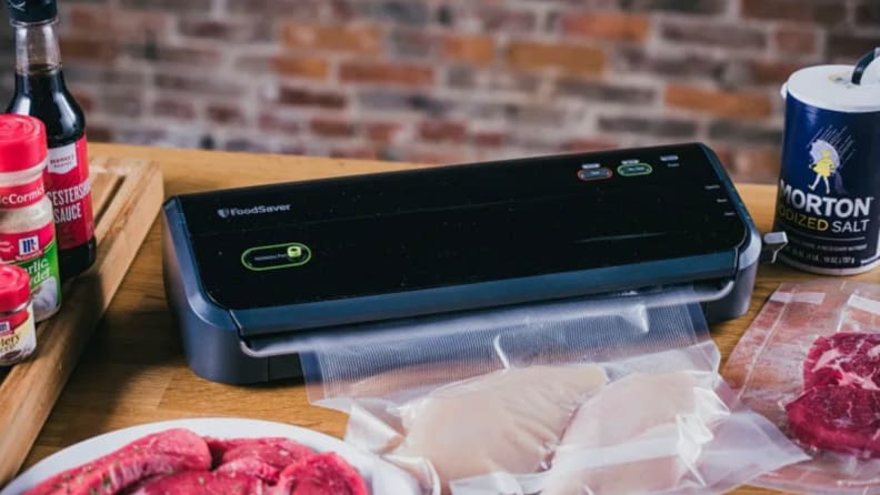 FoodSaver vacuum sealer sealing a bag of raw chicken.