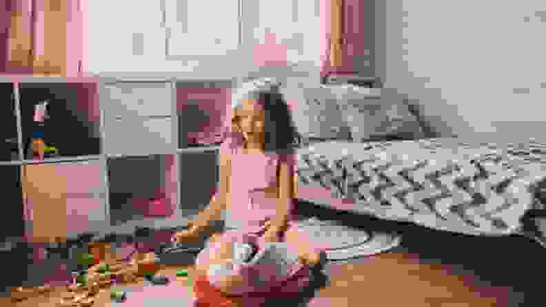 A child plays with blocks on their bedroom floor.