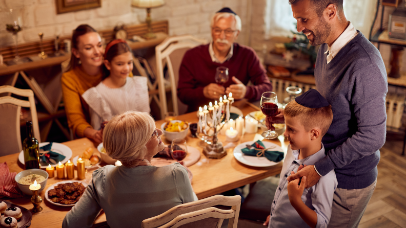 A family celebrating Hanukkah together around a dining table.