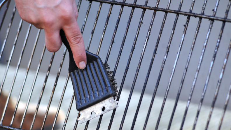 Person using wire brush on dirty grill grates