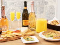 Spread of mimosas and brunch food on wooden table