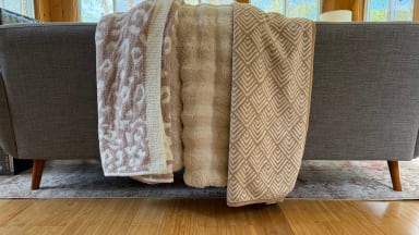 Three throw blankets placed on a couch