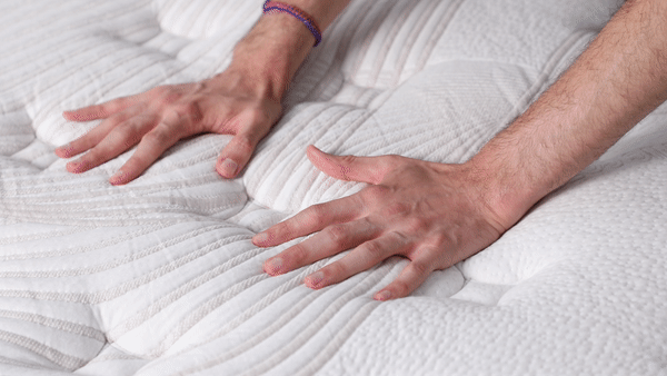 A GIF of a pair of hands pushing down on the mattress.