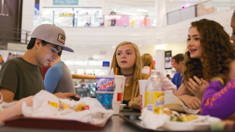 Elsie Fisher, teenage star of Bo Burnham’s Eighth Grade, sits with a group of schoolmates in the food court of a shopping mall.