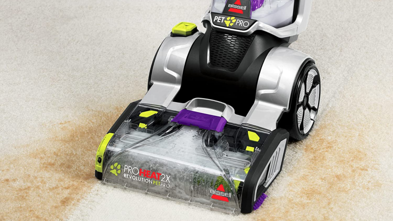 A dirty carpet being cleaned using a Bissell carpet cleaner.