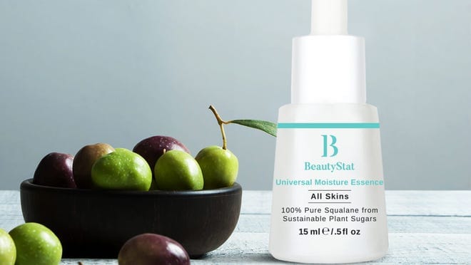 A bottle of BeautyStat next to a bowl of fruit.