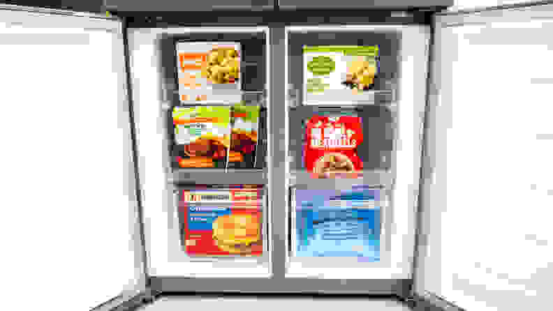 A close-up of the Frigidaire FFBN1721TV French door refrigerator's open freezer compartments, filled with frozen food for scale.