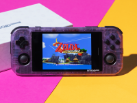 A clear purple gaming handheld with Android home screen on top of a grey Nintendo Switch