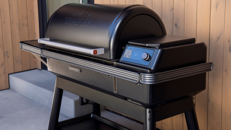 The Traeger Ironwood Pellet Grill closed and sitting against the side of a house.
