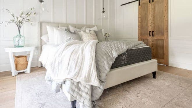 Black Puffy mattress in earth-toned bedroom with white comforter