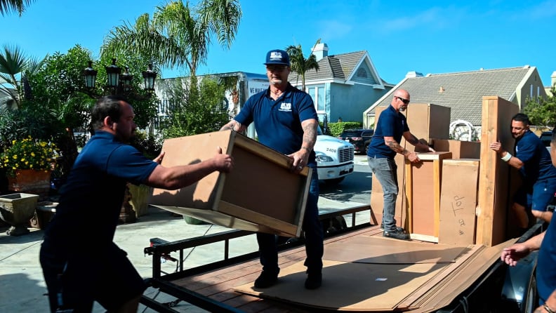 Movers carefully unloading boxes from a truck