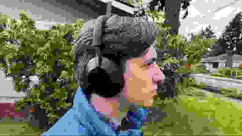 A person wearing the XM5 headphones outdoors.