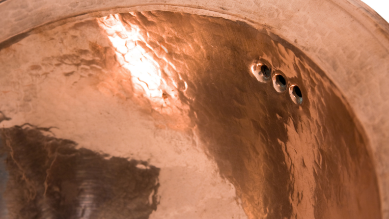 Detail of a round copper sink bowl.