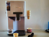 The Cuisinart Mix It In ICE-48 on a countertop surface with empty ice cream cones next to it.