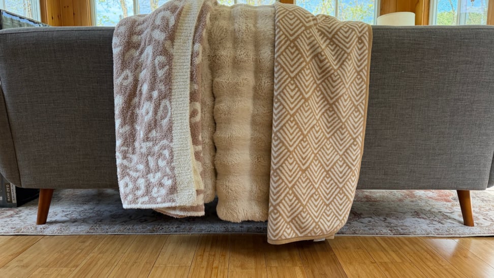 Three throw blankets placed on a couch