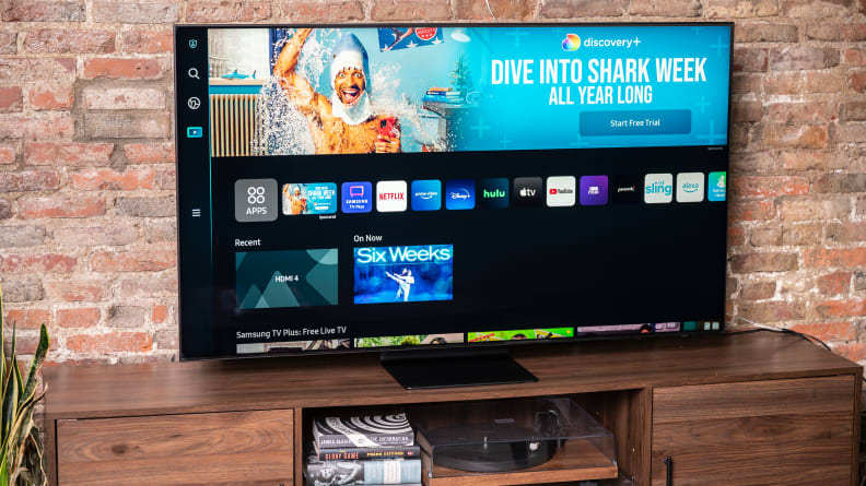 The Samsung QN90B displaying the home screen of its Tizen-based smart platform