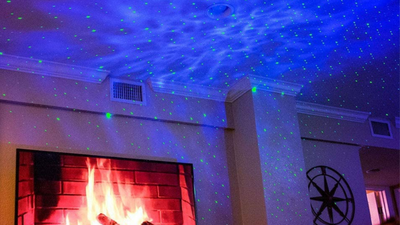 Living room with TV with a blue starry projection on the ceiling and walls