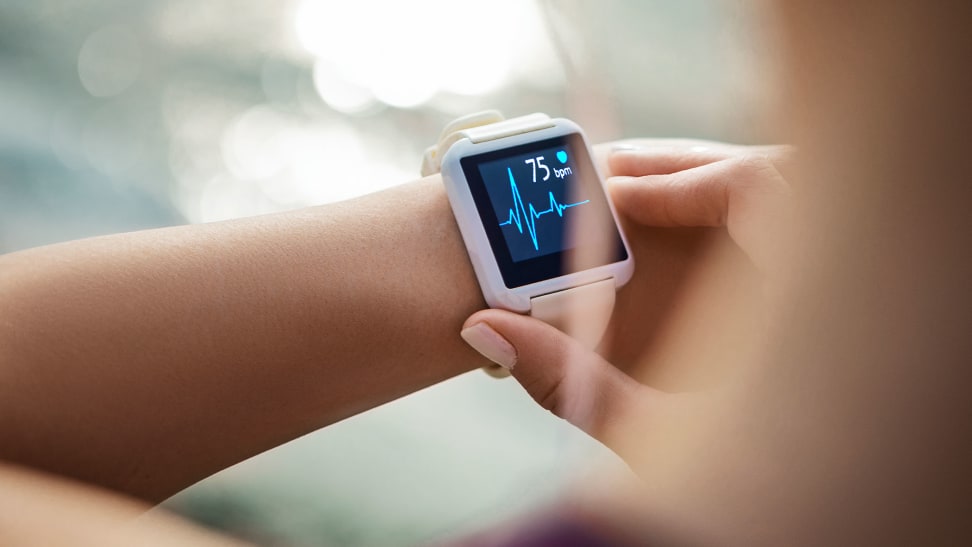 A woman checking her heart rate on a fitness tracker.