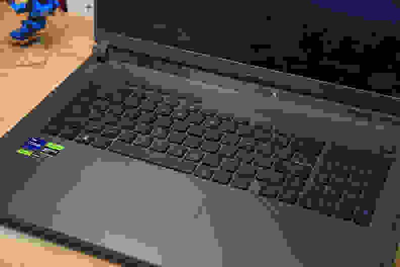 A black laptop on a light brown desk