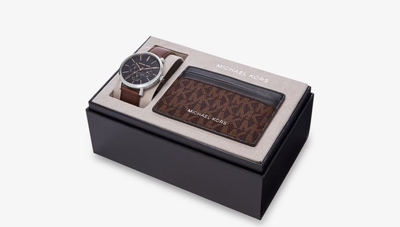 Black box with folded brown leather watch and brown leather wallet.