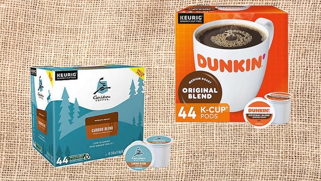 Boxes of Dunkin' and Caribou K-Cups on a brown background.