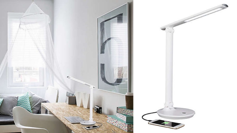 An Ottlite reading lamp sits on a desk in a white room.