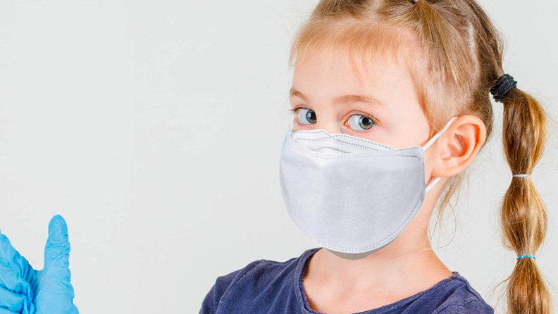 A child wears a surgical mask.