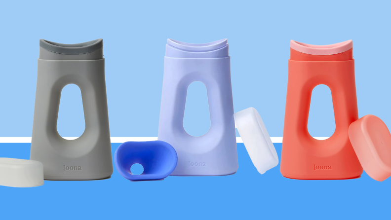 Gray, pastel blue and coral pink portable urinals lined up in a row in front of blue background.