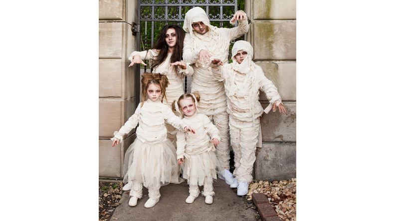 A family of mummies standing in front of a gate.