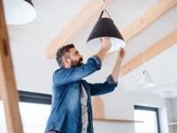 Man changing light bulb to save energy