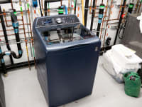 Product shot of the navy colored GE Profile PTW900BPTRS Top-load Washing Machine inside of testing laboratory.