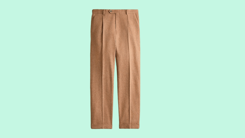 A pair of tweed trousers against a green background.