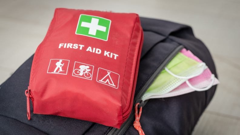 First-aid kit sitting on a backpack.