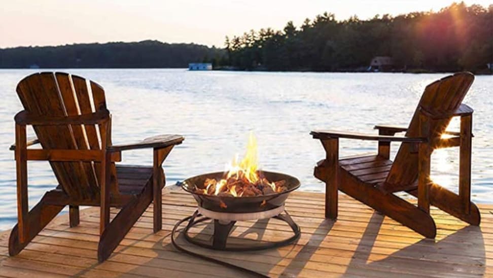 Two Adirondack chairs overlooking the water next to an Outland Firebowl.