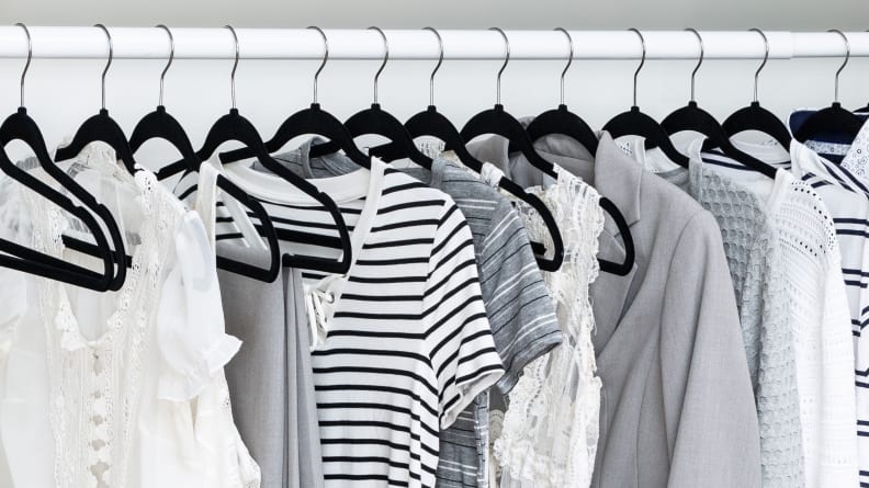 Clothes in closet on black hangers.