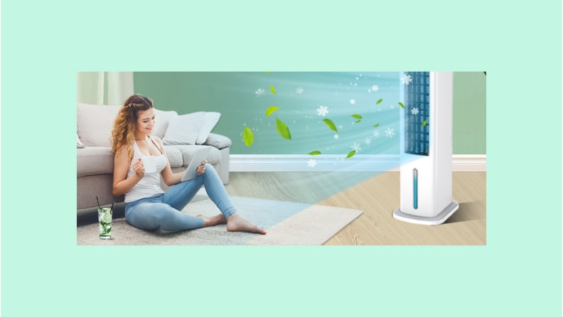 A tower fan blows cool air at a woman sitting in front of a sofa reading on a smart tablet.  The photo is on a teal background.