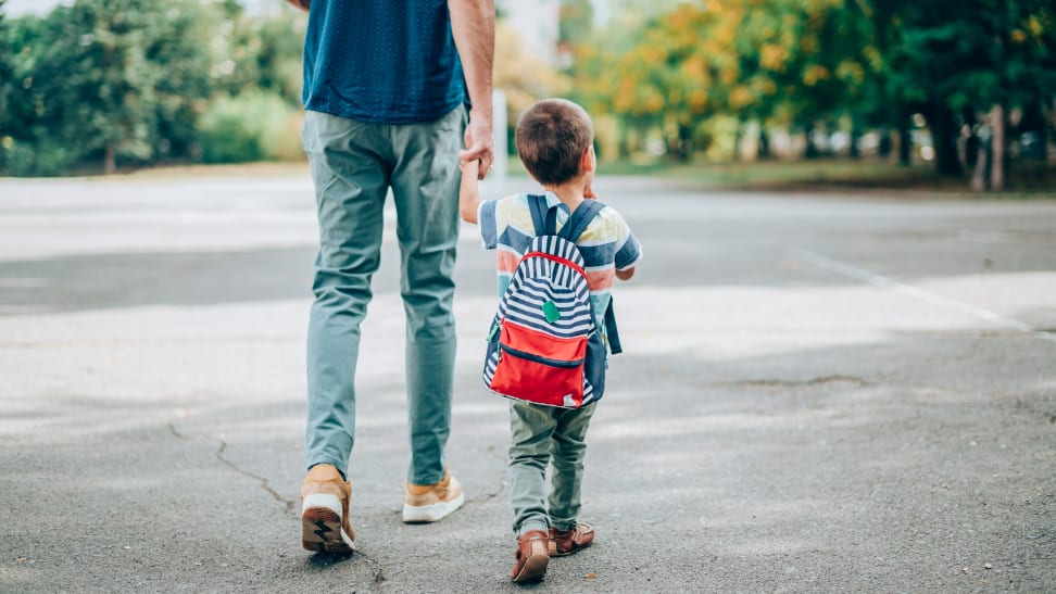 Little boy and dad holding hands and walking to school