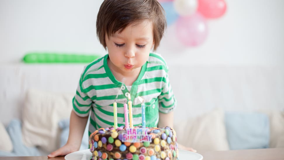 Boy blowing out birthday candles on cake